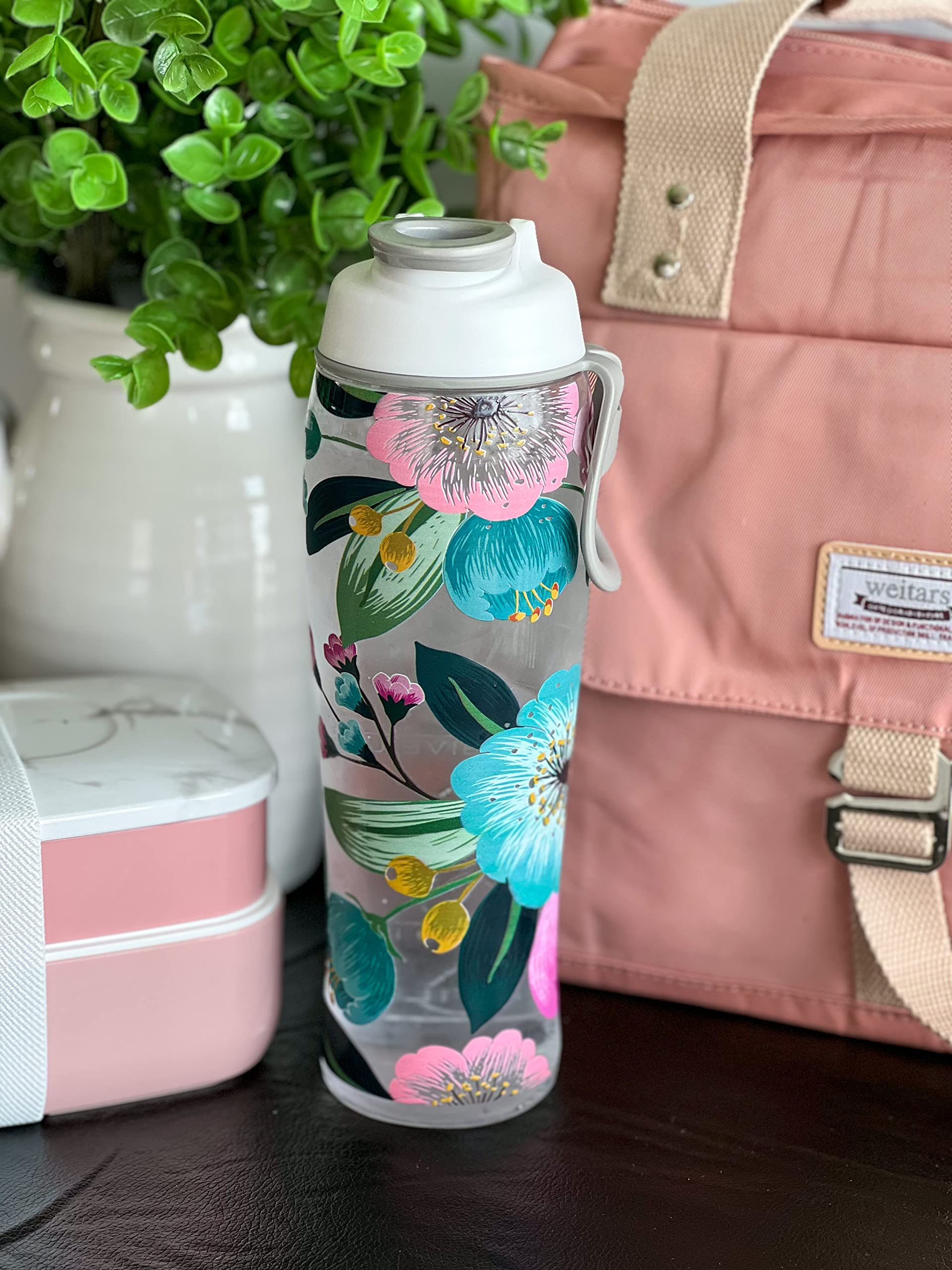 Floral-patterned water bottle with a pink backpack and lunch box in the background